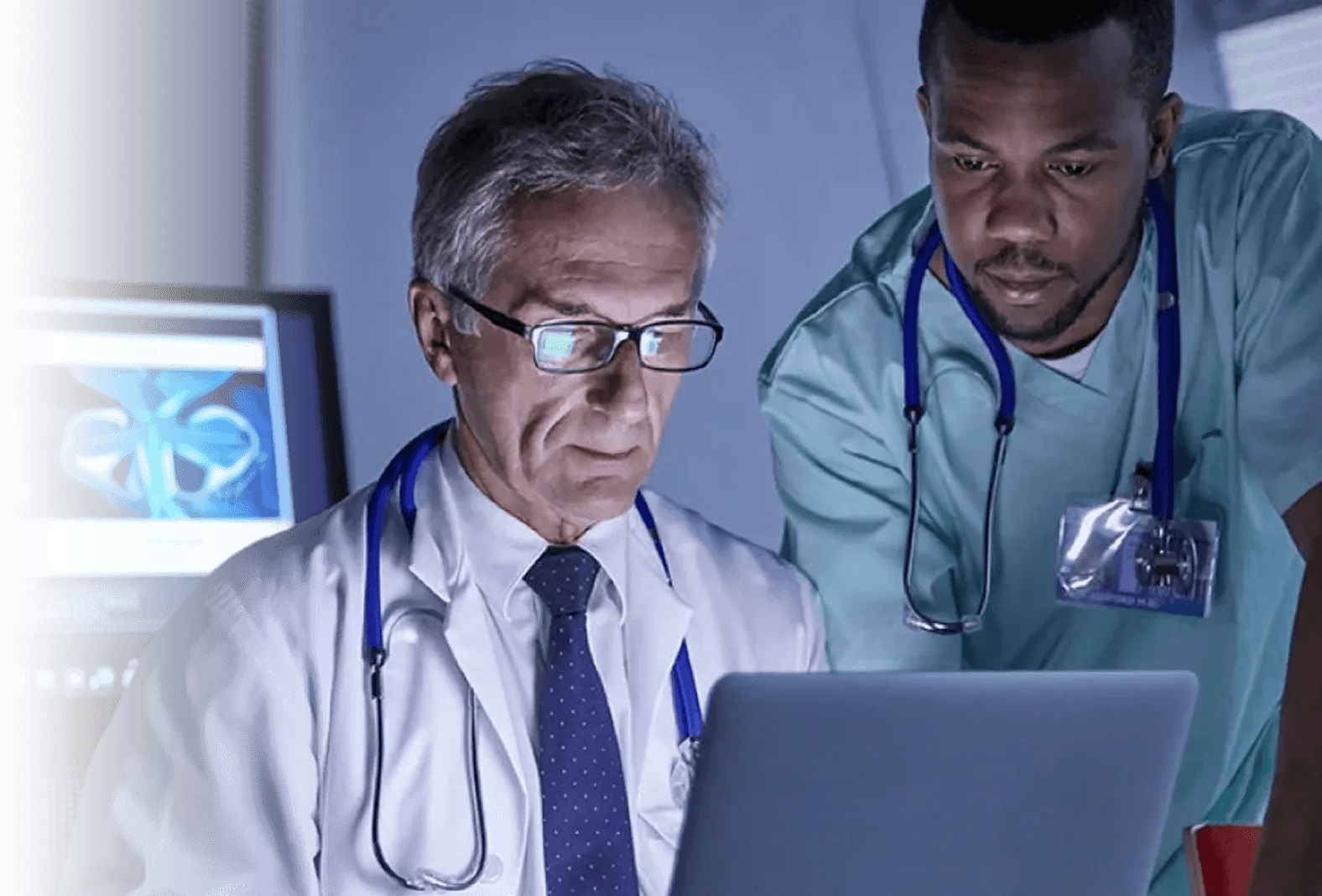 Two clinicians reviewing a study together on a laptop